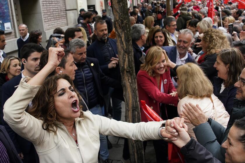 Vice-President of the Spanish Government and Minister of Finance, María Jesús Montero and others government members, cheer to supporters of Spain's Prime Minister Pedro Sánchez gather at the PSOE party headquarter during a demonstration in Madrid, Spain, Saturday, April 27, 2024. Spain is in nail-biting suspense Monday as it waits for Prime Minister Pedro Sánchez to announce whether he will continue in office or not. Sánchez, 52, shocked the country on Thursday, announcing he was taking five days off to think about his future after a court opened preliminary proceedings against his wife on corruption allegations. (AP Photo/Andrea Comas)