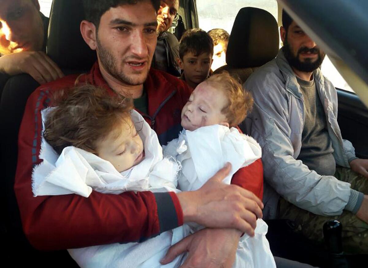 In this April 4, 2017, photo, Abdel Hamid Yousef, holds his twin babies, who were killed in a chemical weapons attack in Khan Sheikhoun, Syria. He lost the twins, his wife and 16 other relatives in the poison gas attack. Determined to continue with his life, Yousef remarried and has an 11-month-old daughter. But tragedy keeps chasing the 31-year-old former shopkeeper.