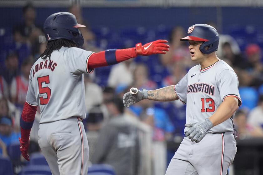 Washington Nationals' CJ Abrams (5) congratulates Nick Senzel (13) after Senzel hit a home run scoring Abrams during the fourth inning of a baseball game against the Miami Marlins, Sunday, April 28, 2024, in Miami. (AP Photo/Wilfredo Lee)