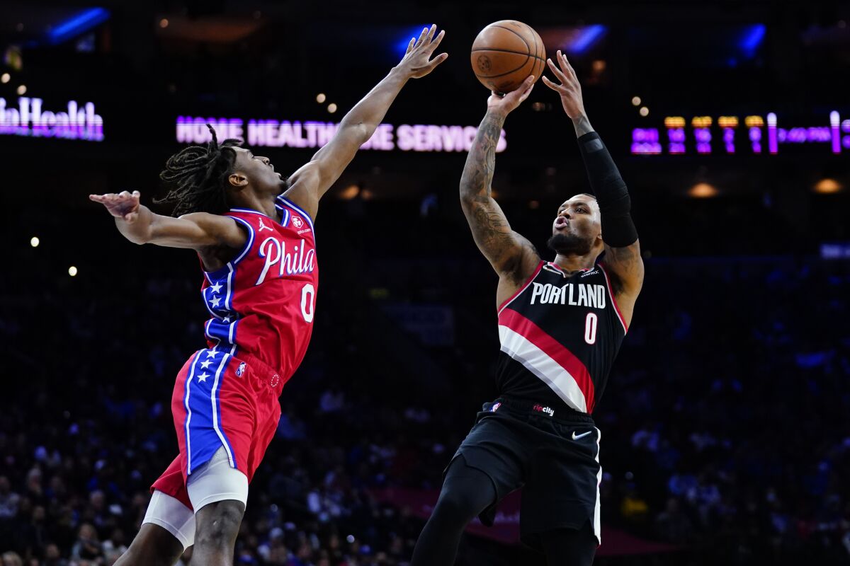 Portland Trail Blazers' Damian Lillard, right, goes up for a shot against Philadelphia 76ers' Tyrese Maxey during the first half of an NBA basketball game, Monday, Nov. 1, 2021, in Philadelphia. (AP Photo/Matt Slocum)
