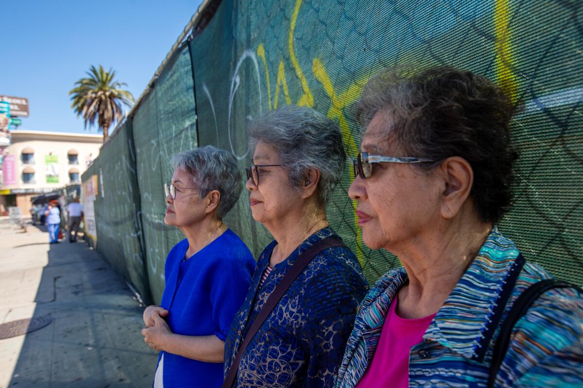 Three women wait for the bus in Koreatown.