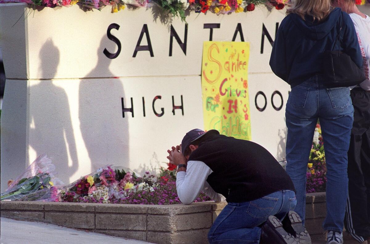 Bill Flynn, of Santee, prays in front of the Santana High School sign/makeshift memorial in the front Santana High School on Magnolia in Santee Ca. Flynn had two kids that graduated Santee High, one in 1999, the other in 1997. — U-T file photo