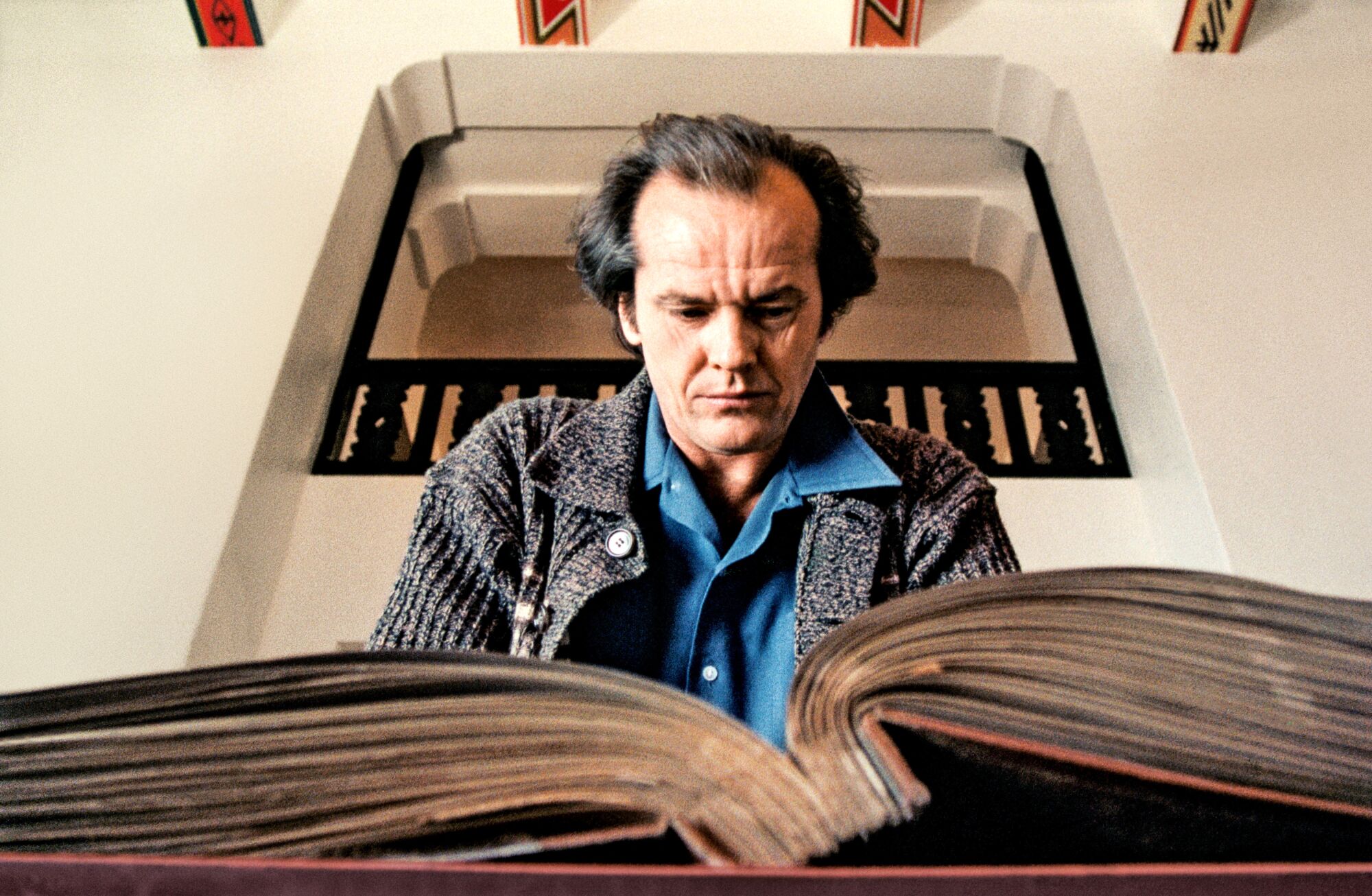 Nicholson, 'The Shining'de hiç kullanılmayan bir çekimde Overlook Hotel'in sefil geçmişini ayrıntılarıyla anlatan bir not defterini inceliyor.