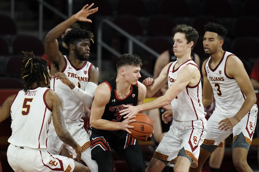 Utah's Pelle Larsson is surrounded by USC players.