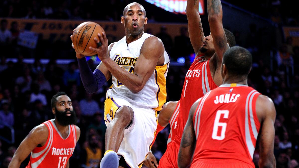 Lakers forward Kobe Bryant looks to pass after driving to the basket against the Rockets during a game Jan. 17.