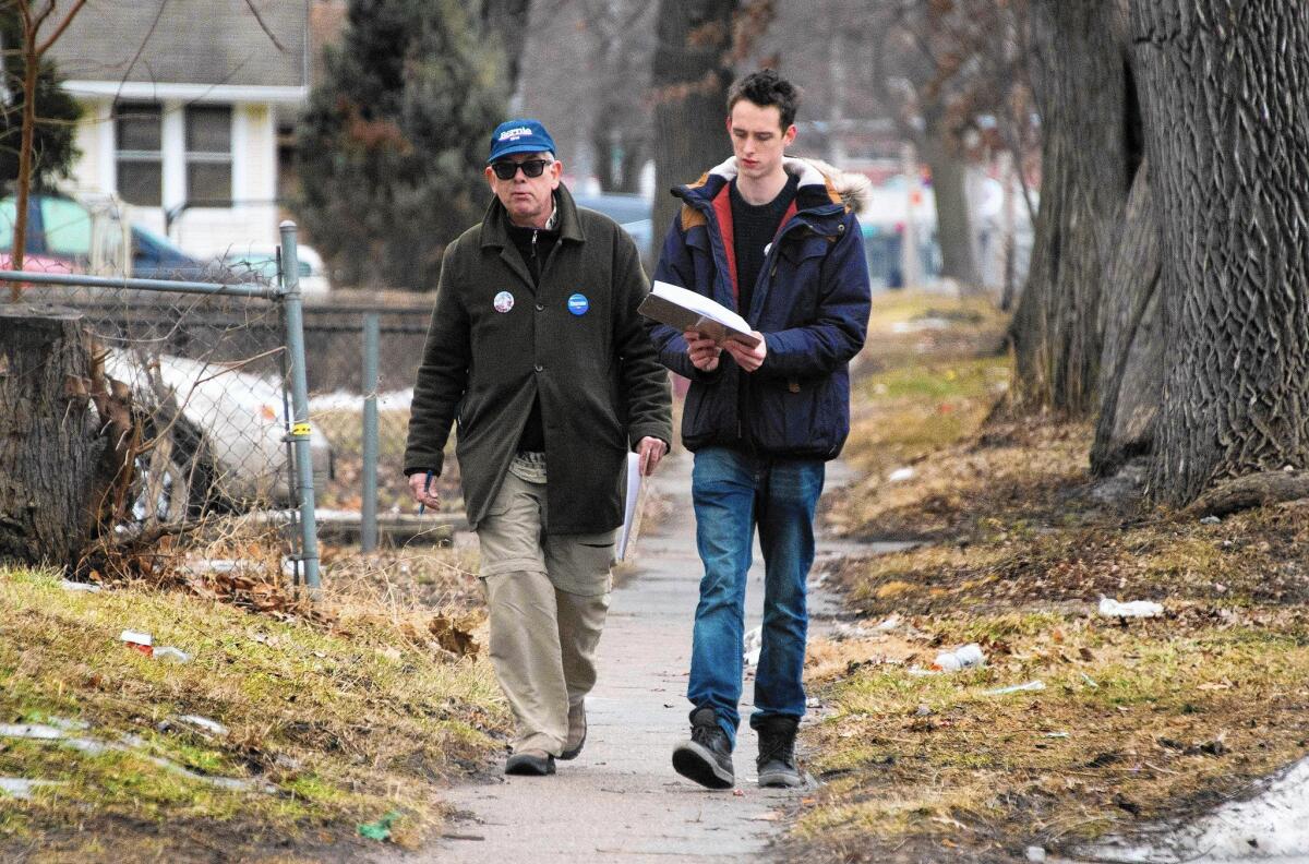 Volunteers Bob Swope, left, and Fergus Wilson canvass for Bernie Sanders in Des Moines on Jan. 31. Swope, a former Occupy protester, drove four hours to the city last week to work for Sanders.