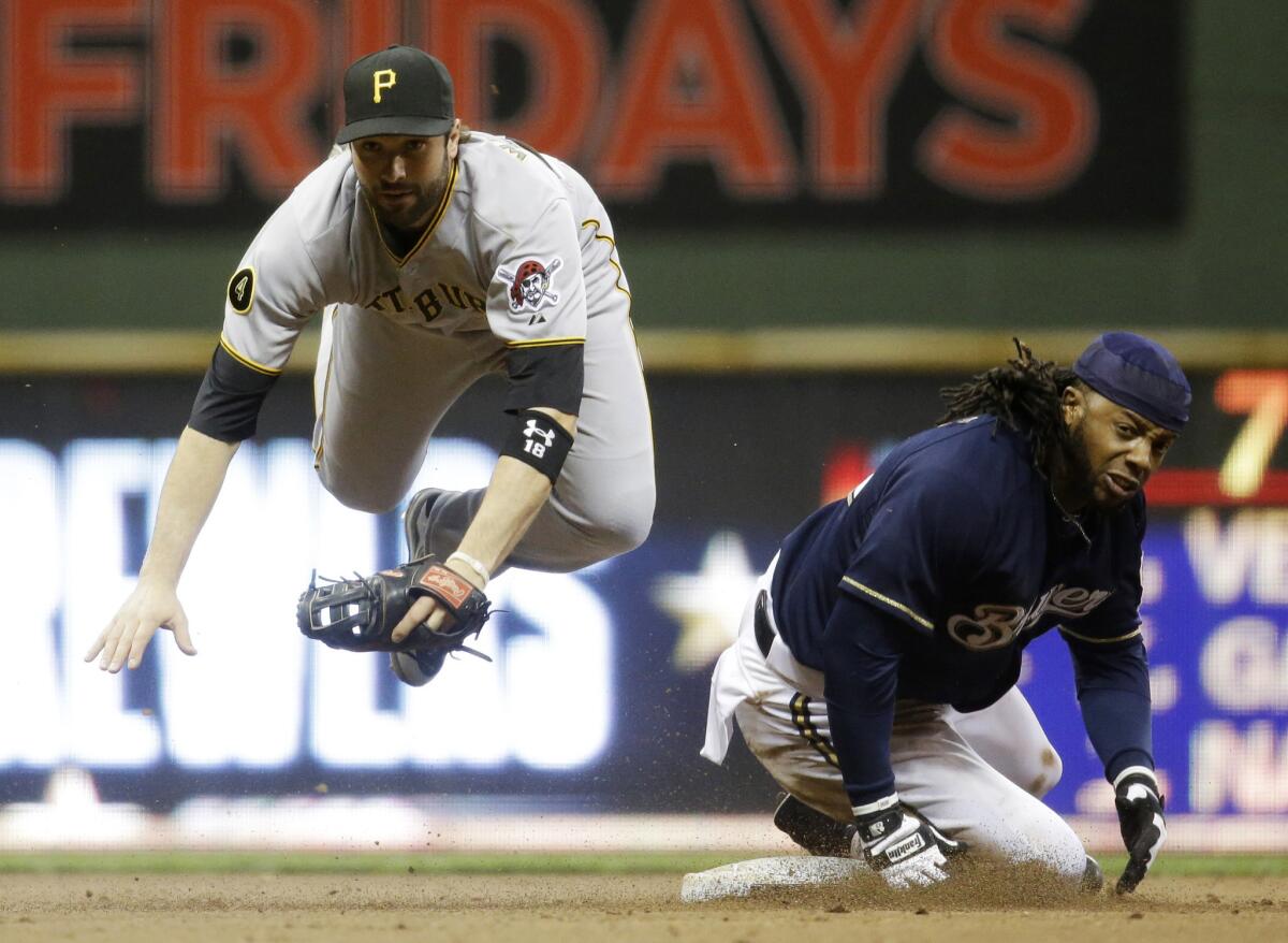 Pittsburgh second baseman Neil Walker leaps over the Brewers' Rickie Weeks to turn a double play Wednesday in Milwaukee.