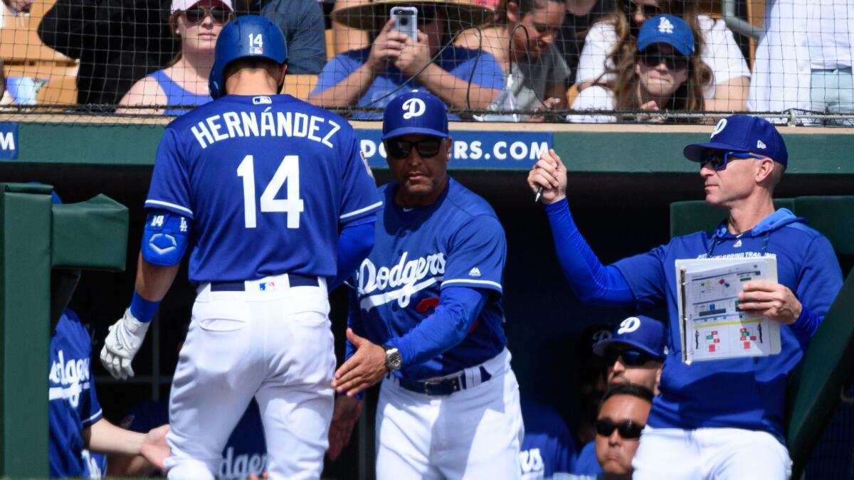 Dodgers manager Dave Roberts congratulates Enrique Hernandez, who hit a solo home run March 9 during a spring training game against Seattle.