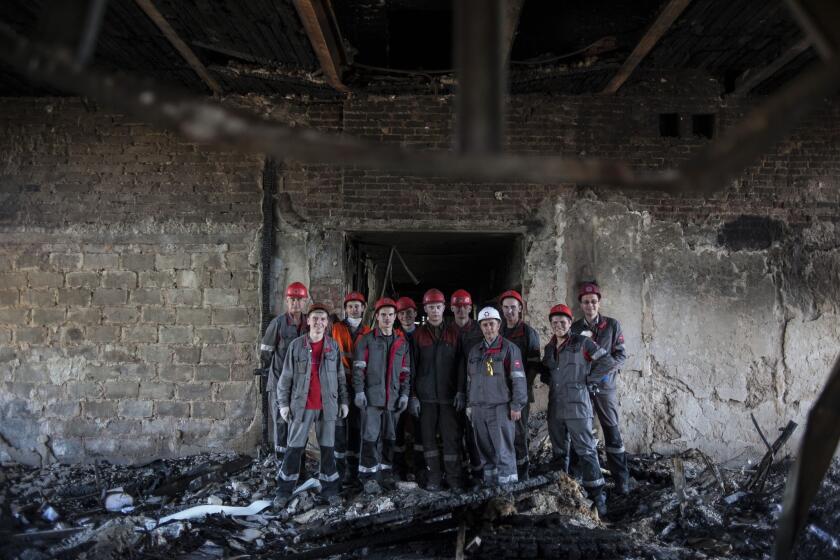 Steelworkers employed by Metinvest, a Ukrainian conglomerate, pose for a photo during a break from clearing away debris in a government building in Mariupol that was seized by separatists.