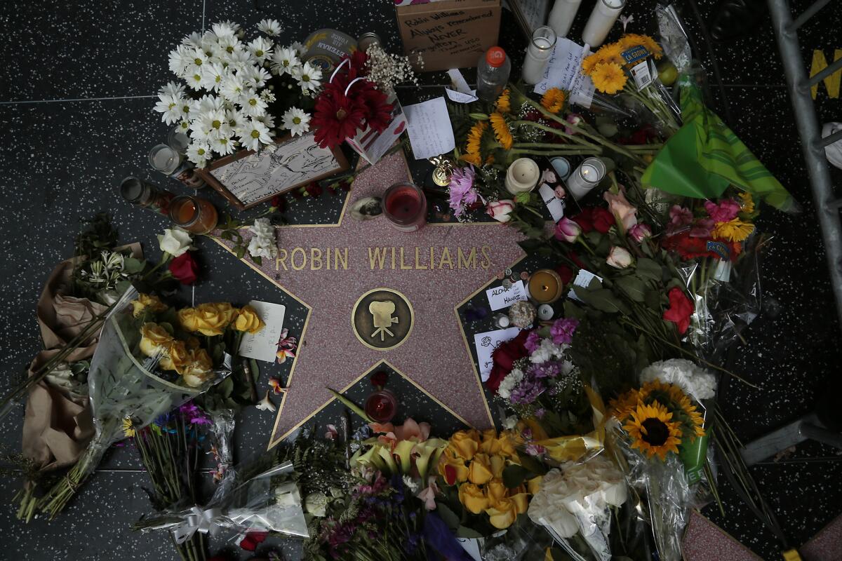 Flowers and memorabilia are piled on Robin Williams' Hollywood Walk of Fame star, a day after the actor was found dead from an apparent suicide.