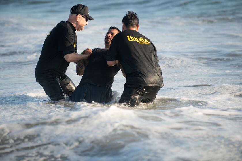 Josh Lorenzo of Bell Gardens was one of over 6,000 people baptized at Huntington State Beach.
