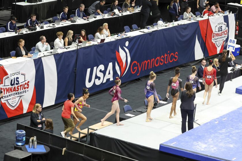 FILE - Signage showing the new USA Gymnastics logo is displayed during the 2022 U.S. Gymnastics Championships, Friday, Aug. 19, 2022, in Tampa, Fla. The sport of gymnastics' international investigations agency was created in 2019 to help protect athletes after the American sexual abuse scandal. The Gymnastics Ethics Foundation has now published its strategy to set new standards in safeguarding before the 2028 Los Angeles Olympics. The “Gymnasts 2028” details goals for its work to protect athletes from harassment and abuse, investigate complaints, prosecute disciplinary cases and monitor national federations. (AP Photo/Mike Carlson, File)