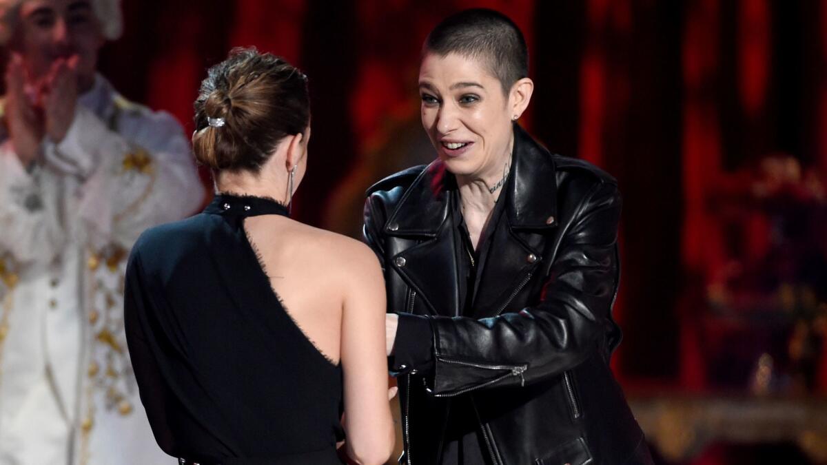 Asia Kate Dillon, right, presents the award for actor in a movie to Emma Watson for her role in "Beauty and the Beast" at the MTV Movie & TV Awards.