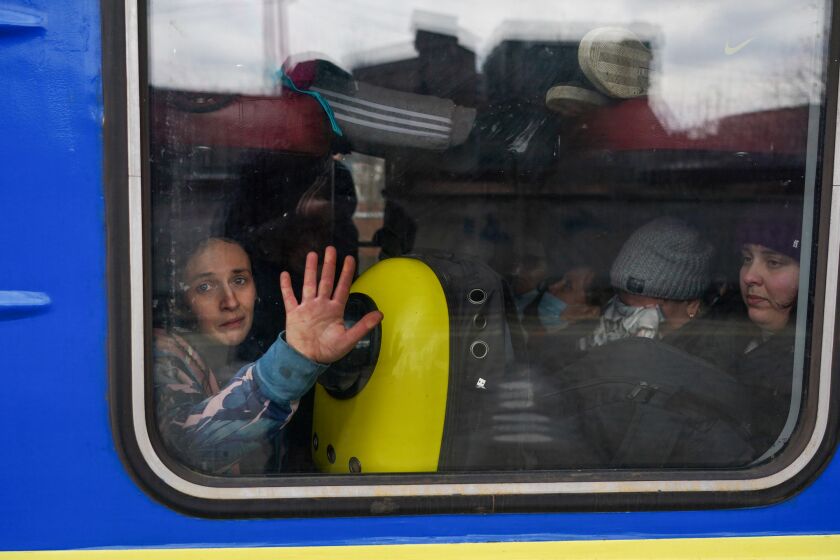 Civilians, mostly women and children rush to board any train car that still has any room on it
