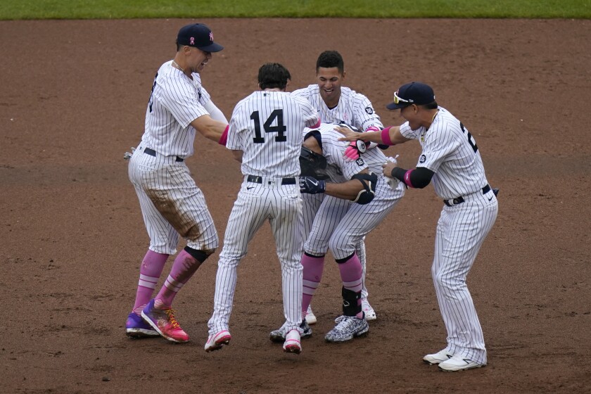 Teammates mob New York Yankees' Giancarlo Stanton, center, after he hit a walkoff single during the ninth inning of a baseball game against the Washington Nationals at Yankee Stadium, Sunday, May 9, 2021, in New York. (AP Photo/Seth Wenig)