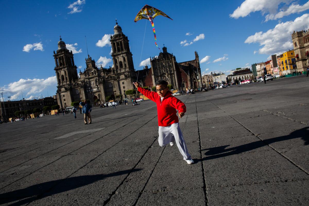 Gustavo Anguiano Arzaluz, 9, flies a kite during a windy day at Zocalo square in Mexico City.