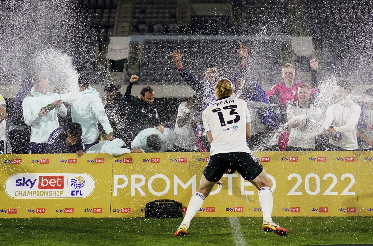 Fulham celebrates their promotion to the Premier League after the League Championship soccer match against Preston at Craven Cottage, in London, Tuesday, April 19, 2022. Fulham has secured an immediate return to the Premier League after a 3-0 win over Preston guaranteed a top-two finish in the League Championship. (Adam Davy/PA via AP)