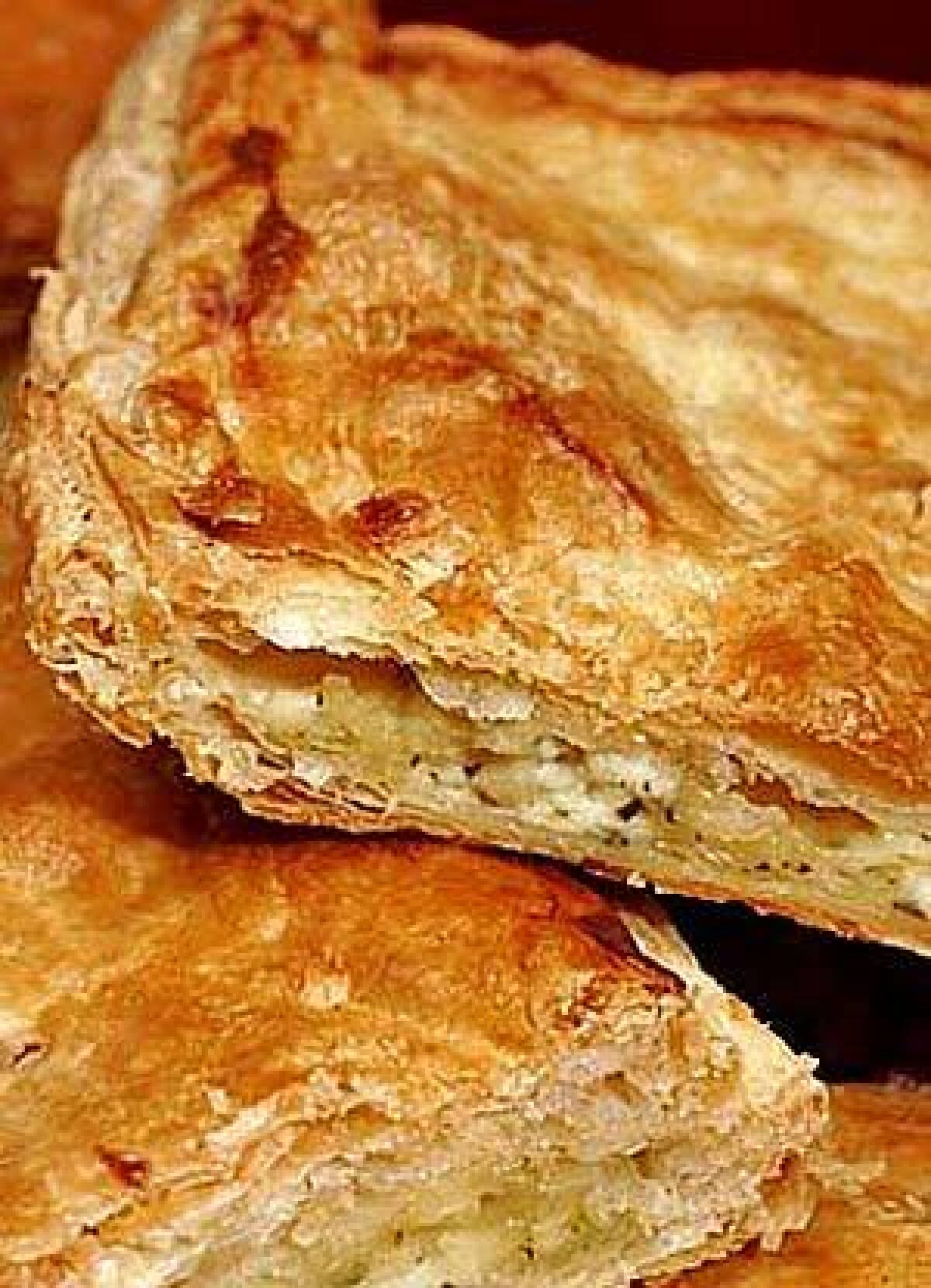 This Russian savory cheese pie combines grated mozzarella and feta and is seasoned with fresh cilantro and dill and baked in store-bought puff pastry.