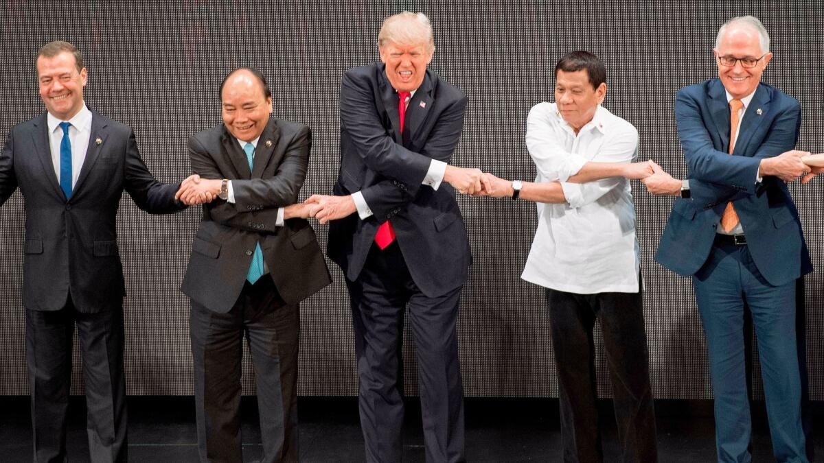 President Trump joins hands with, from left, Russian Prime Minister Dmitry Medvedev, Vietnamese Prime Minister Nguyen Xuan Phuc, Philippine President Rodrigo Duterte and Australian Prime Minister Malcolm Turnbull for the group photo opening the ASEAN summit in Manila.