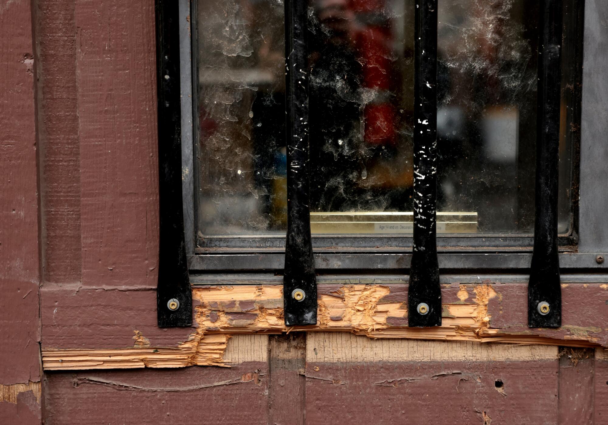 A windowsill with parts torn away and vertical black bars