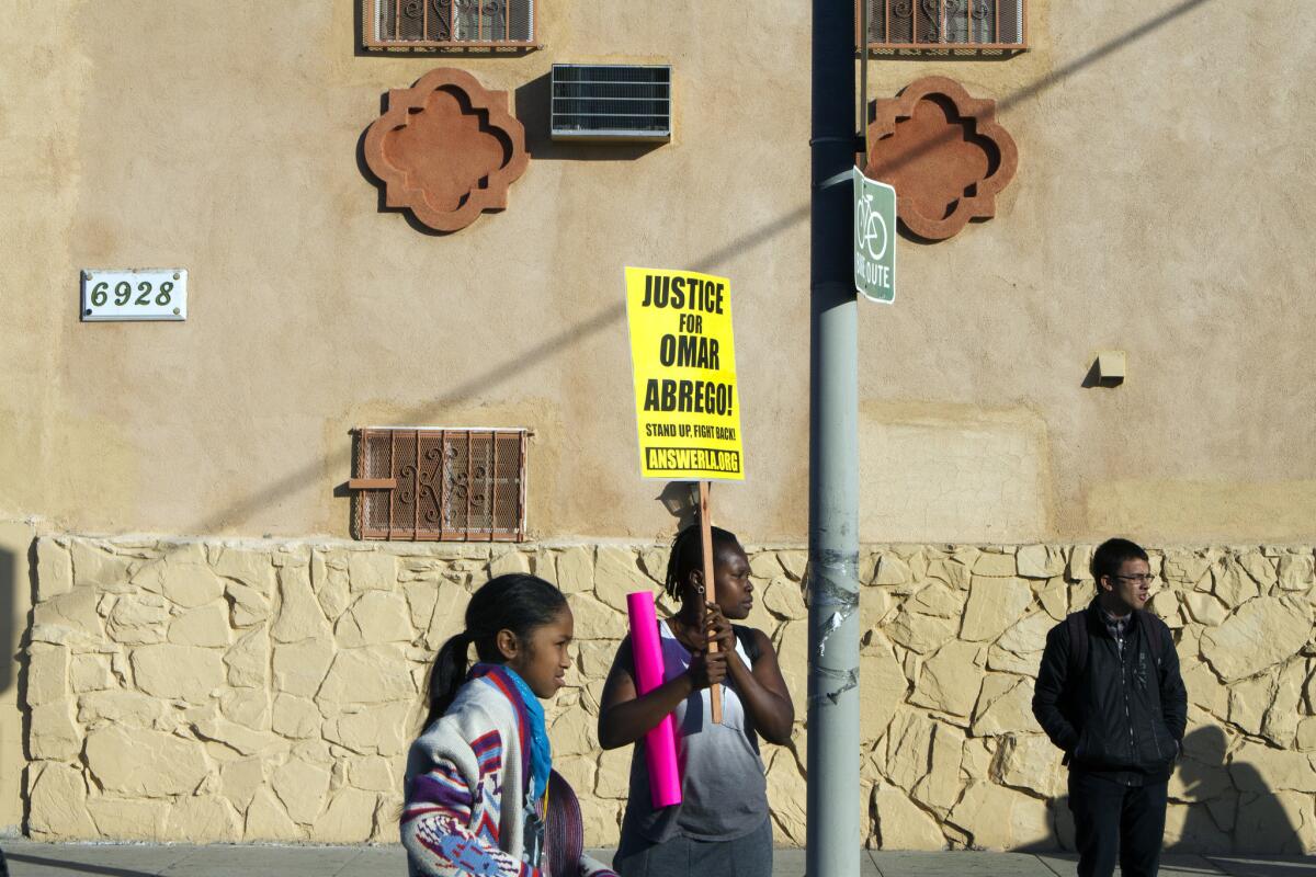 Lawrencia Colding, center, protests at 65th Street and Broadway in South Los Angeles on Jan. 3 over the death of Omar Abrego, who died hours after being arrested by police last year.