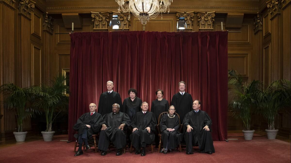 The justices gather for a formal group portrait at the Supreme Court Building in Washington on Nov. 30.