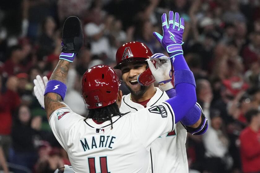 Arizona Diamondbacks' Lourdes Gurriel Jr., rear, celebrates his two-run home run against the Colorado Rockies with Ketel Marte during the first inning of a baseball game Thursday, March 28, 2024, in Phoenix. (AP Photo/Ross D. Franklin)