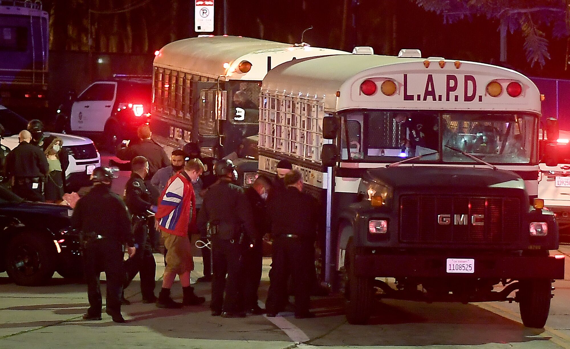 Protestors board an LAPD bus after being arrested in Echo Park Thursday night.