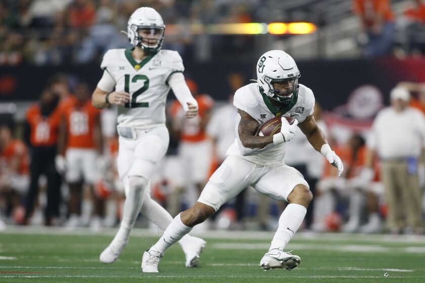 Baylor running back Abram Smith (7) runs the ball as quarterback Blake Shapen (12) looks on against Oklahoma State in the first half of an NCAA college football game for the Big 12 Conference championship in Arlington, Texas, Saturday, Dec. 4, 2021. (AP Photo/Tim Heitman)