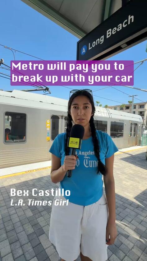A woman stands on a train platform.