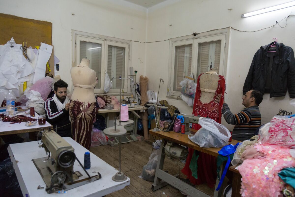 Tailors work on belly dancing costumes at Zaki's shop. (Sima Diab / For The Times)
