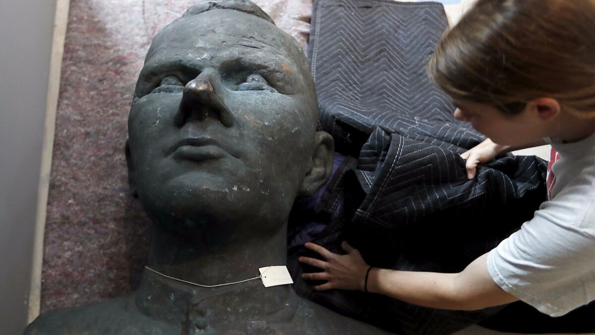 A bust of Russian cosmonaut Yuri Gagarin gets unwrapped for installation at the Wende Museum.