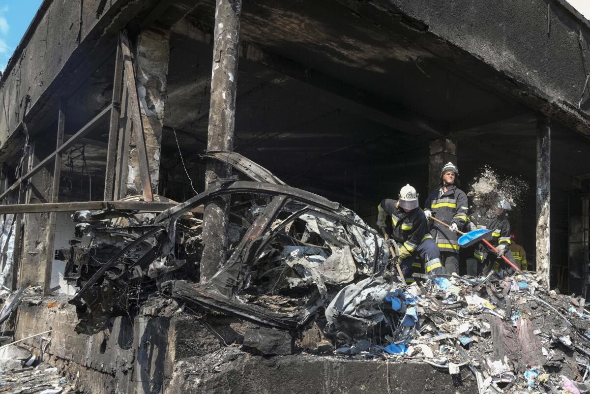 Rescuers amid debris of building damaged by Russian missile attack