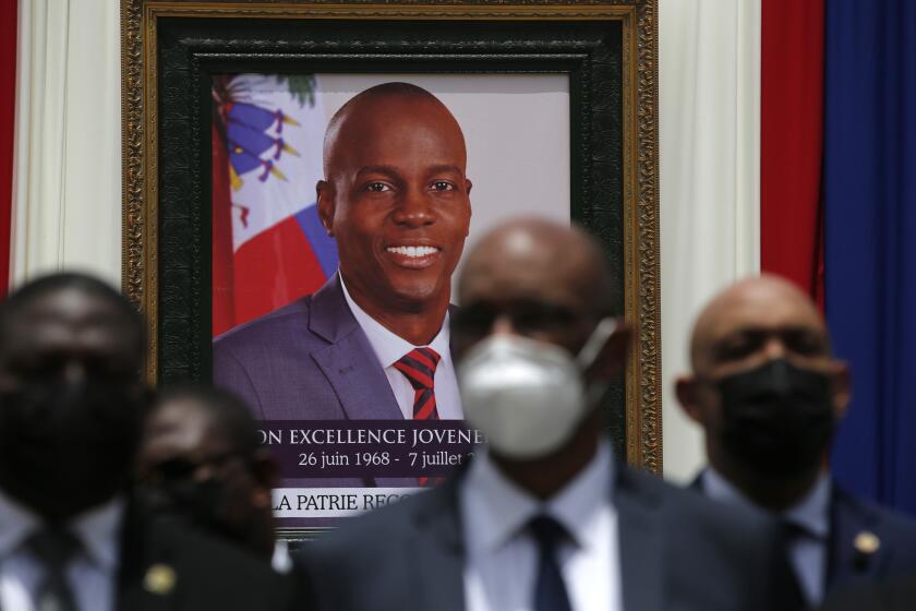 FILE - In this July 20, 2021 file photo, authorities pose for a group photo in front of the portrait of late Haitian President Jovenel Moise at at the National Pantheon Museum during his memorial service in Port-au-Prince, Haiti. Moise was assassinated on July 7 at his home. (AP Photo/Joseph Odelyn, File)