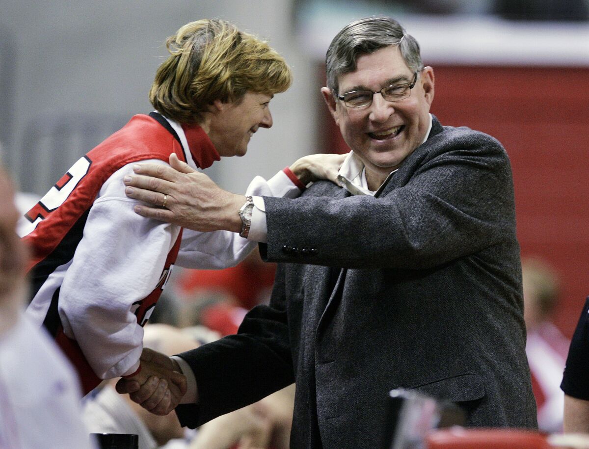 FILE - Rutgers athletic director Robert E. Mulcahy III, right, is greeted by a supporter Thursday, Dec. 11, 2008, in Piscataway, N.J., before a women's basketball game. Mulcahy, who served as athletics director for the state’s flagship university and held many high-ranking government posts during his decades of service, has died. Mulcahy’s family announced his death Tuesday, Feb. 8, 2022, saying he had passed away Monday after a long illness. (AP Photo/Mel Evans)