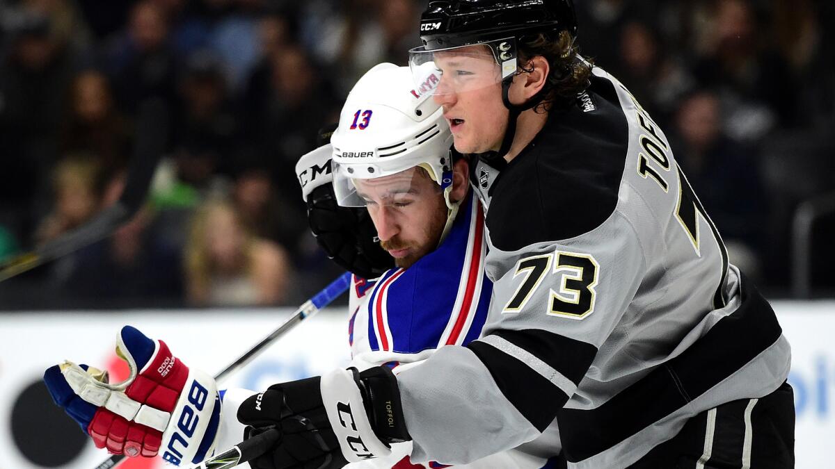 Kings center Tyler Toffoli tries to hold his position in front of the crease as he's checked by Rangers winger Kevin Hayes during the second period Saturday night. (Harry How / Getty Images)