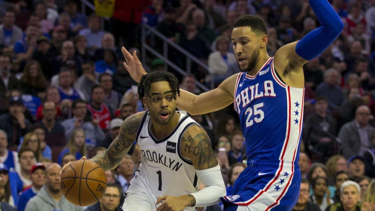 Brooklyn Nets' D'Angelo Russell, left, drives to the basket against Philadelphia 76ers' Ben Simmons in the first quarter of Game 2 of the first round of the NBA playoffs on Monday.