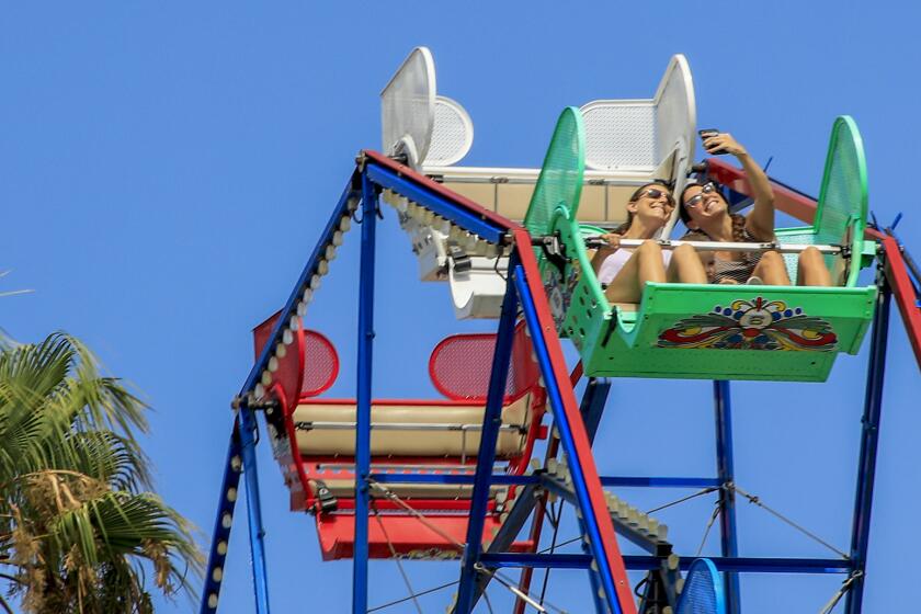 NEWPORT BEACH, CA., SEPTEMBER 2, 2019: Riders on the Ferris Wheel at the Balboa Fun Zone take selfies on Labor Day September 2, 2019. Hot temperatures inland and the holiday sprit are driving people to the coast where cool breezes and big waves greeted Labor Day crowds (Mark Boster For the LA Times).