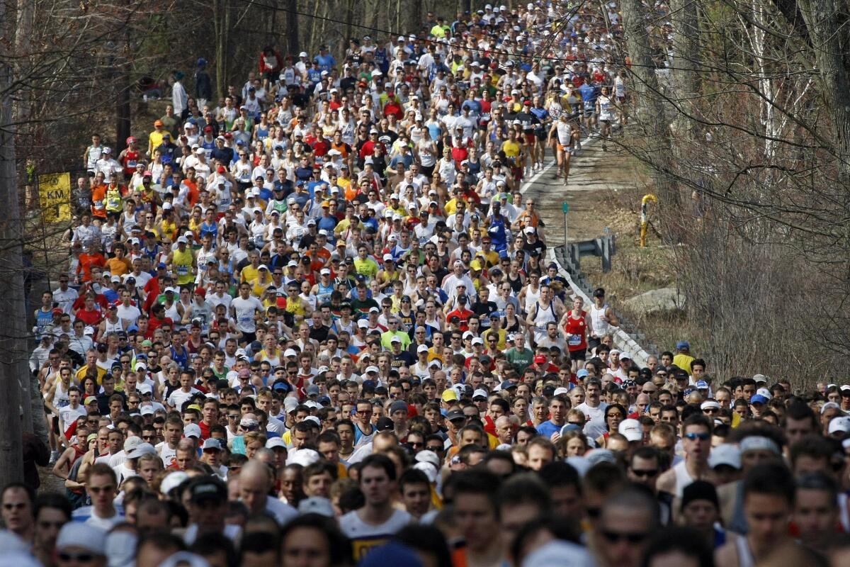 Runners round a curve and climb a hill during the first mile of the 2008 Boston Marathon. 
