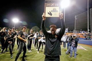 FULLERTON, CA - MAY 20: Brett Kay, head coach of JSerra Catholic, holds up a plaque celebrating the Lions 3-1 win over Notre Dame (SO) in the Southern Section Division 1 baseball final played at Cal State Fullerton on Friday, May 20, 2022 in Fullerton, CA. (Gary Coronado / Los Angeles Times)