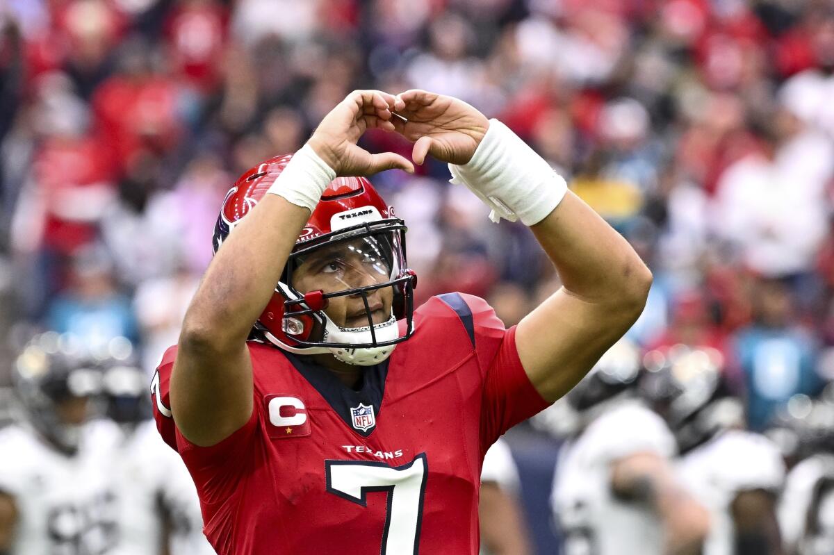 Houston Texans quarterback C.J. Stroud gives a heart sign to the fans.