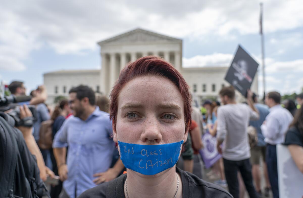 A woman with blue tape across her mouth. 