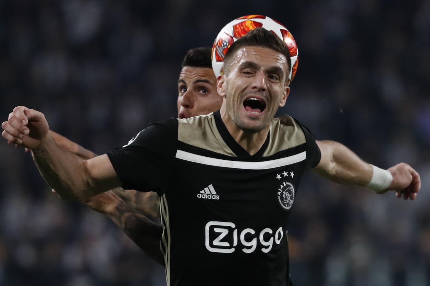 Juventus' Emre Can, left, and Ajax's Dusan Tadic fight for the ball during the Champions League quarter final, second leg soccer match between Juventus and Ajax, at the Allianz stadium in Turin, Italy, Tuesday, April 16, 2019.