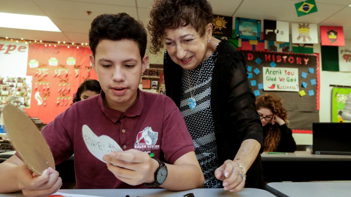 Gabriella Karin works with student Jason Orellana on an art project inspired by her life during World War II.