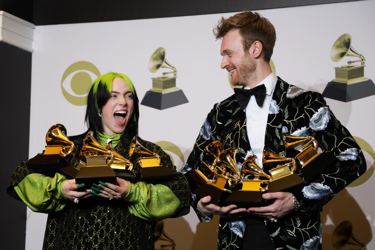 Billie Eilish and Finneas O'Connell hold their Grammy Awards.