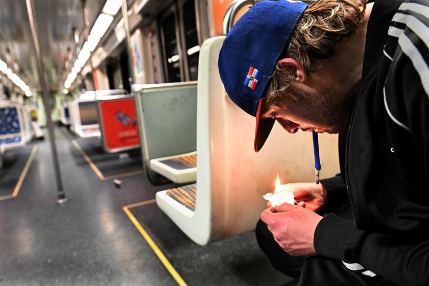 At right, seated on a subway train, a young man with dark blonde hair and a baseball cap smokes fentanyl 