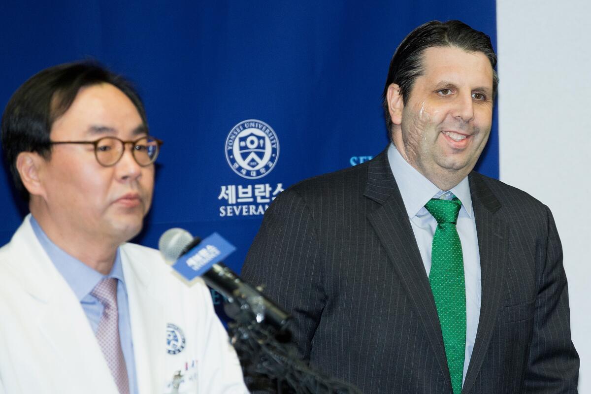 U.S. Ambassador to South Korea Mark Lippert, right, attends a news conference Tuesday about his release from the hospital after being slashed on his face and wrist by a knife-wielding man at a function in Seoul last week.