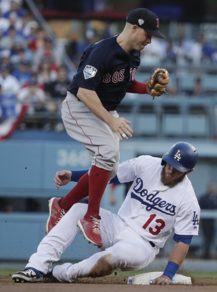 Max Muncy slides hard into second base after he is forced out by Boston Red Sox second baseman Brock Holt in the first inning.