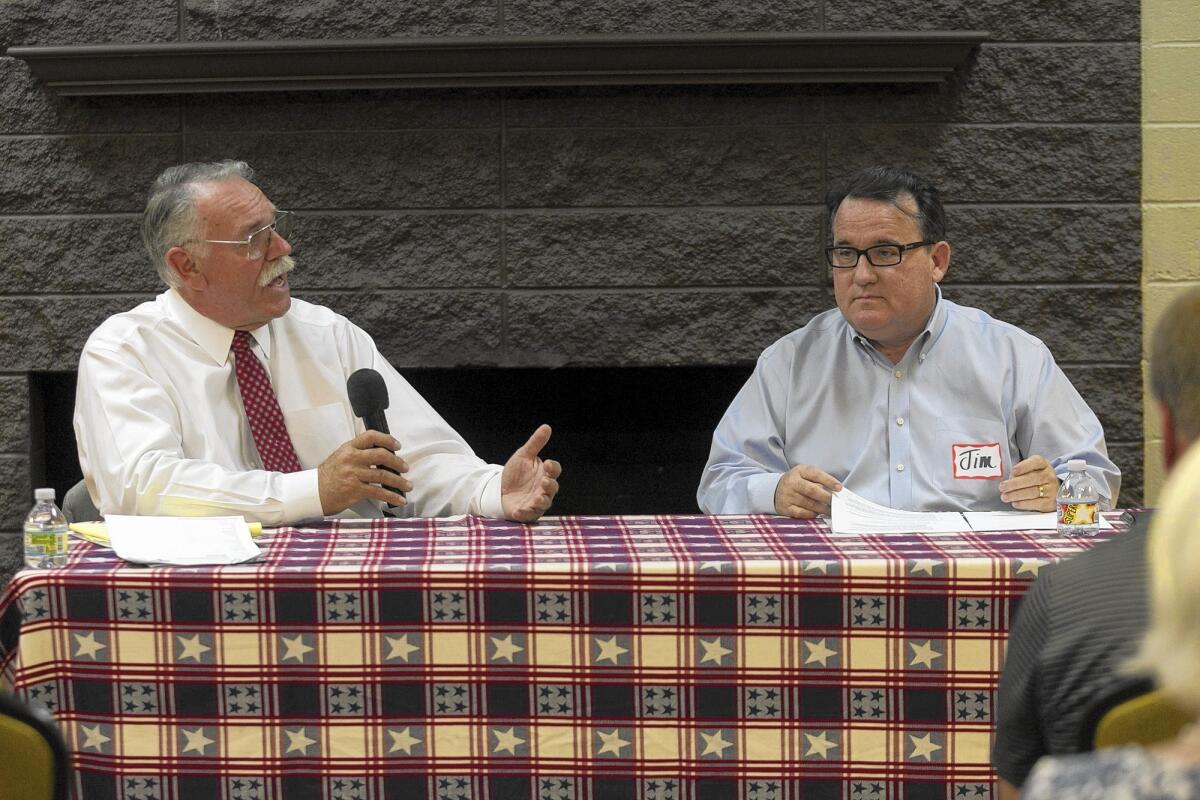 Costa Mesa City Council candidate Jay Humphrey, left, and Mayor Pro Tem Jim Righeimer debate the merits of a resident-sponsored growth-control initiative on Tuesday at Halecrest Park.