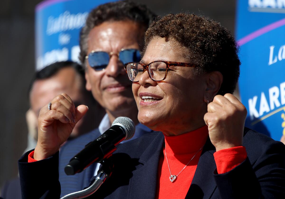 Karen Bass gestures while speaking into a microphone